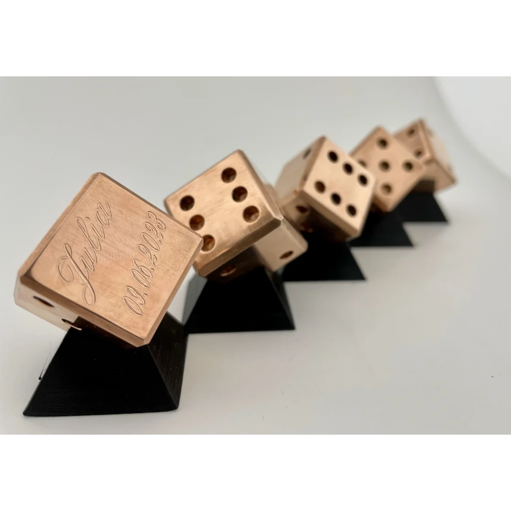 A group of UNLIMIT3D FIVE - Set of 5 Dices in Brass, Copper or Stainless steel sitting on top of each other.