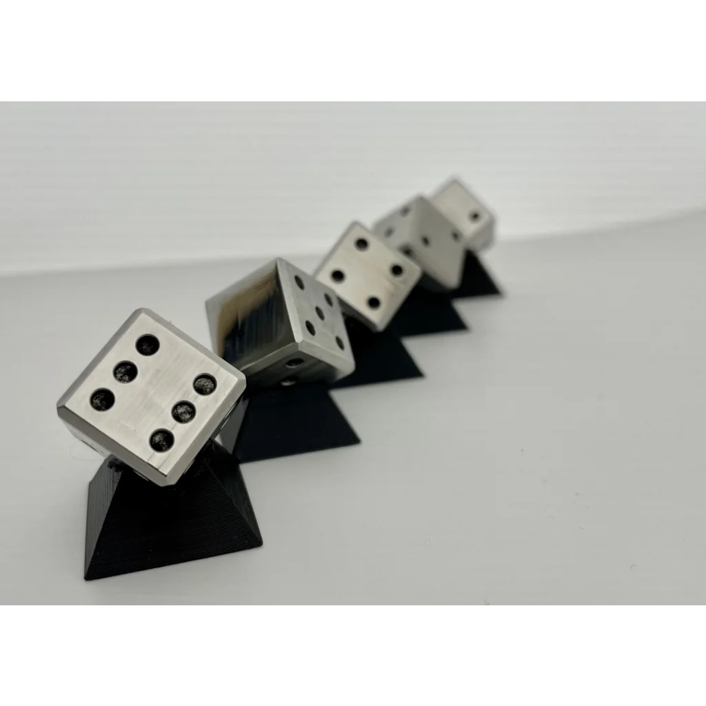 A group of UNLIMIT3D FIVE mini - Set of 5 Mini Stainless Steel Dice sitting on top of each other.