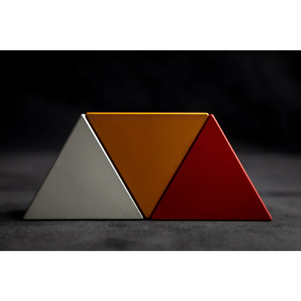 A CRYPT3D Troika by UNLIMIT3D, a triangle shaped object, sitting on top of a table.